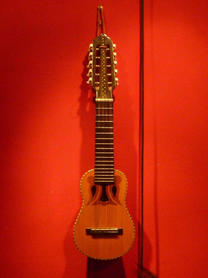 Charango (südamerikanisches Saiteninstrument) auf roter Wand